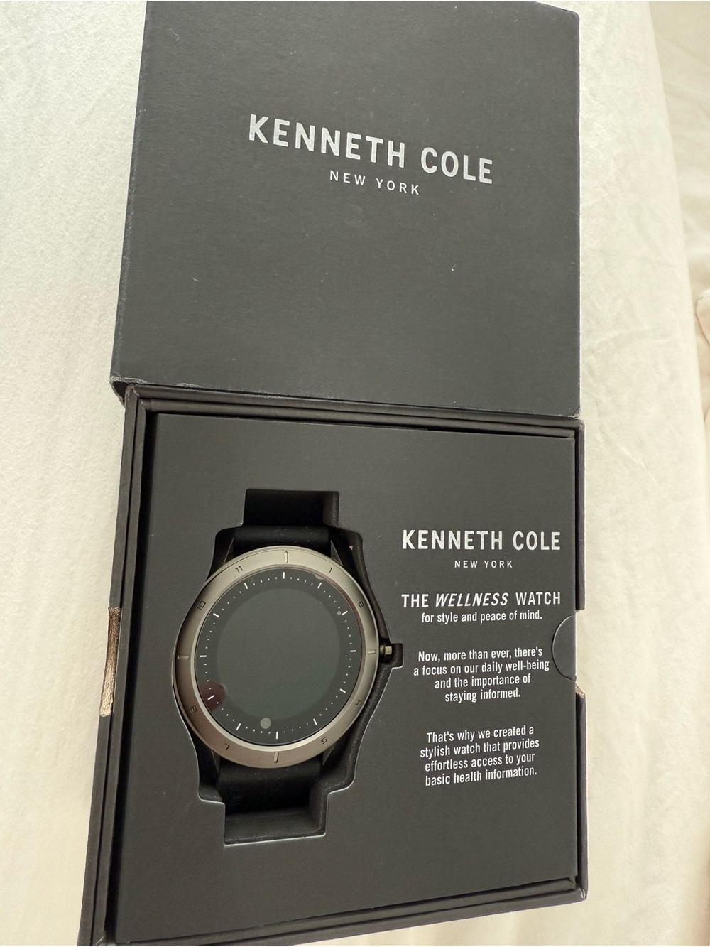 Kenneth Cole Wellness Smartwatch in black and silver with charger cable